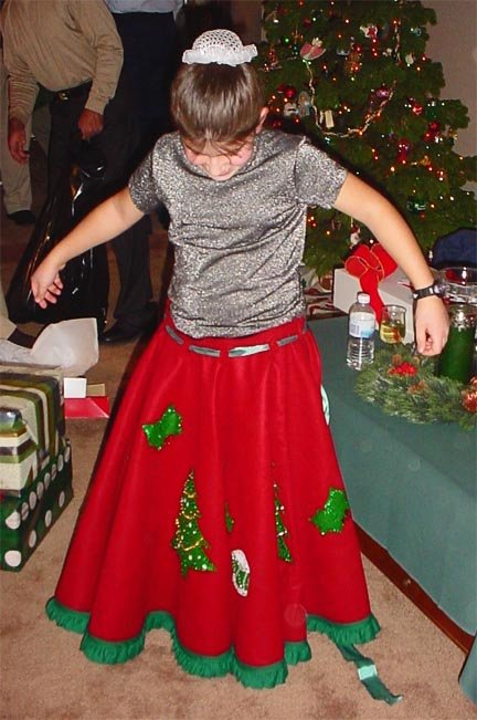 Abbey wearing a red and green Christmas tree skirt.