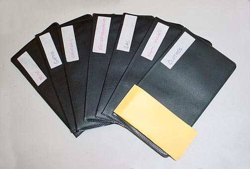 A fanned shape of black plastic money budgeting envelopes with a white label on each one. Bart & Nancy Good thinks this is the best budget system there is.