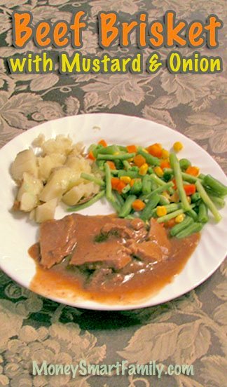 Plate of beef brisket with mustard and onion gravy with mixed vegetables and baked potato on a white plate.