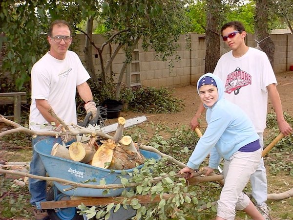 Tree trimming using a chain saw, hand saws and rakes.