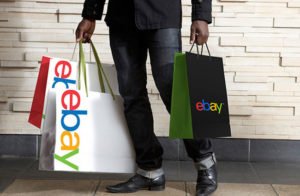 A person holding ebay shopping bags
