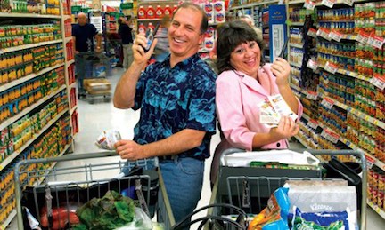 Steve & Annette Economides in the grocery store with walkie talkies.