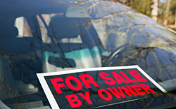 A for sale by owner sign sitting on the windshield of a car.