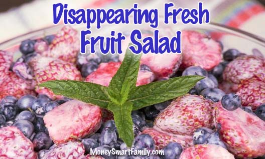 Fresh fruit salad in a glass bowl full of blueberries, strawberries and raspberries.