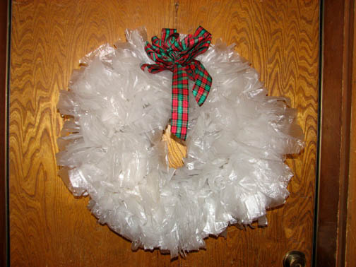 Plastic grocery bag wreath on an oak door.