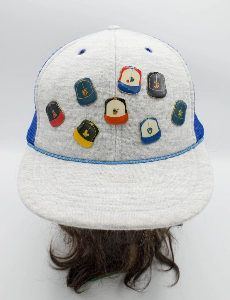 a baseball cap with hat pin souvenirs on it.