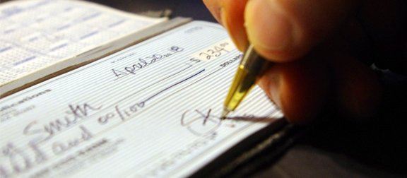 Places that will cash a personal check. Writing a check with a gold pen.