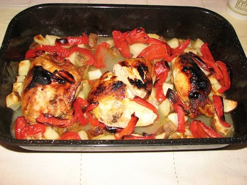 Chicken and peppers recipe in a black enamel pan.