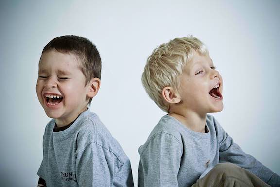 Two laughing boys playing games that make you laugh.