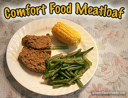 A white plate with green beans, half ear of corn and 2 slices of meatloaf.