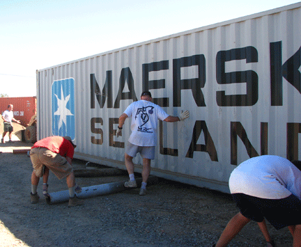 A team of kids moving a storage container.