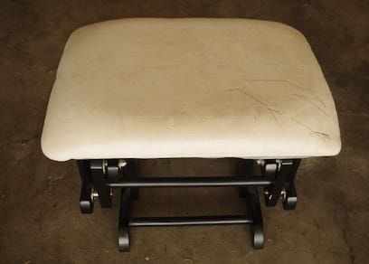Microfiber Ottoman foot stool with ink stain scribbles on it.