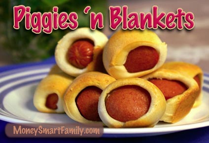 Piggies in blankets stacked on a white plate with blue trim.