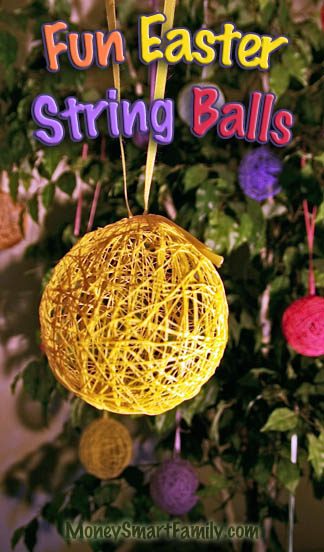 A Yellow string ball hanging from a yellow ribbon on a ficus tree, decorated for Easter.