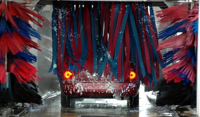 A car going through a car wash to check for water leaks to prepare for winter.